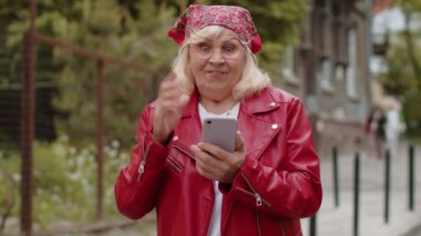 Aman Tanrım. Vay canına. Heyecanlı, mutlu, mutlu, son sınıf güzeli kadın akıllı telefon daktilo kullanarak kutlama yapıyor ve iyi haber kazanıyor. Şehir caddesinde yürüyen cep telefonlu yaşlı bir büyükanne.
