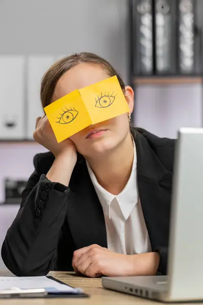 在办公室的办公桌前 工作在笔记本电脑上 脸上贴着眼睛的疲倦的女商人正在睡觉 懒散的经理 自由职业者女孩 商人们为了睡觉而作弊 垂直方向 — 图库照片