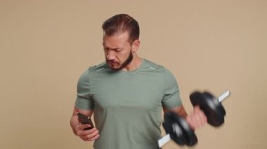 Sporcu adam cep telefonu daktilosu kullanıyor. 