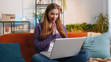 Aman Tanrım. Vay canına. Laptop bilgisayarı kullanan genç bir kadın, iyi haber mesajı alıyor, ani zaferi kutluyor piyango galibiyetini evde online alışveriş yaparak kutluyor. Yaşam tarzı teknolojileri