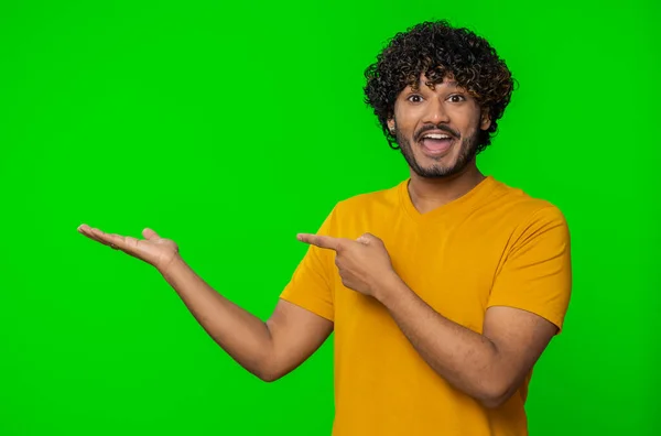 快乐的印度年轻人竖起大拇指 指着空旷的地方 商业广告版块 商品促销横幅的复制空间 在色心背景上被隔离的印度教男人 — 图库照片