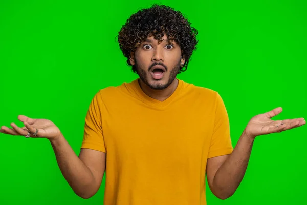 What Why. Sincere irritated indian man raising hands in indignant expression asking reason of failure demonstrating disbelief irritation by trouble. Confused hindu guy on green chroma key background