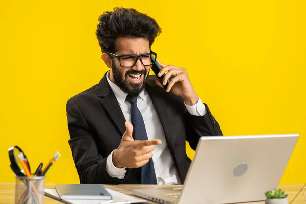 Conflict Quarrel. Angry businessman ceo making webcam laptop online video call at office. Mad freelancer man talking on smartphone colleague conversation analyzing financial report mistake problem