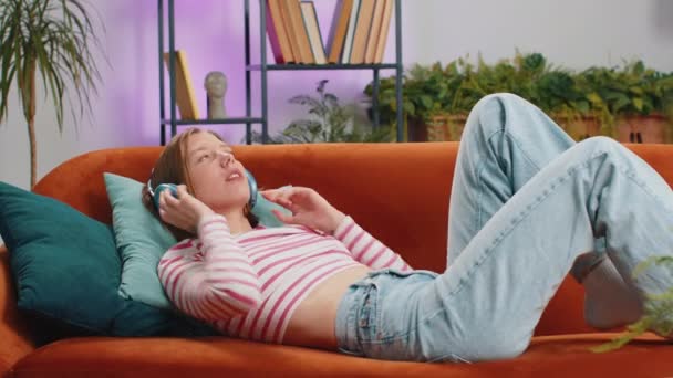 Brunetka Szczęśliwa Rozradowana Kobieta Bezprzewodowych Słuchawkach Relaksująca Się Kanapie Domu — Wideo stockowe