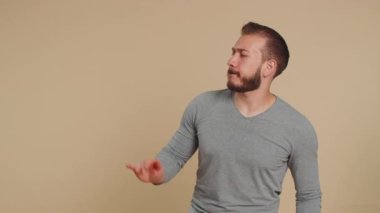 Lübnanlı modaya uygun, neşeli Lübnanlı adam dans edip ritme ayak uyduruyor, el kaldırıyor, dublaj yapıyor, başarıyı kutluyor, kazanıyor. Orta Doğulu adam bej arka planda izole edilmiş.