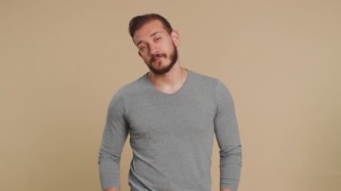Lübnanlı genç adam ilgisiz ifadelerden sıkılmış, sıkıcı hikayelerden bıkmış, iletişim konuşmalarıyla ilgilenmeyen, hoşnutsuzlukla ilgilenmeyen, ilginç olmayan. Orta Doğulu adam bej arka planda izole edilmiş.