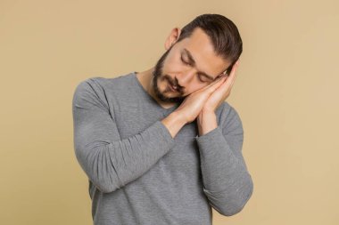 Çok çalışan Lübnanlı genç adam uykusuzluktan uykusuzluktan uykusuz, tembel, uykusuzluktan ağzı açık gezmekten sıkılmış. Tükenmiş Orta Doğulu adam stüdyo bej arka planında izole edilmiş.