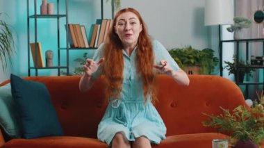 Kazanan, başarıyı kutlayan, gol atan, iyi haber, piyango talihi, evdeki hayaller gerçek oluyor. Kariyer büyür. Kanepede oturan kızıl saçlı kız.