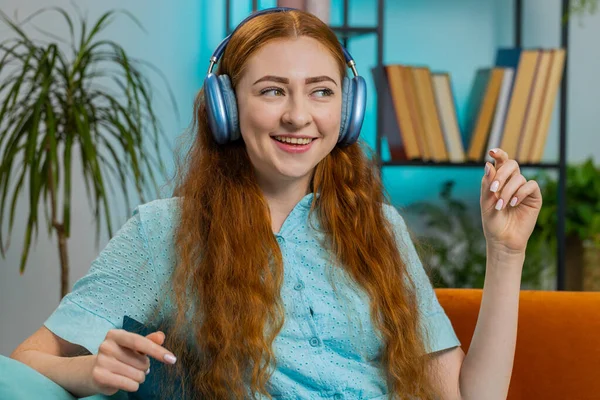 아파트 소파에 헤드폰으로 긴장을 행복해 여성의 활기넘치는 디스코 음악을 듣기로 — 스톡 사진