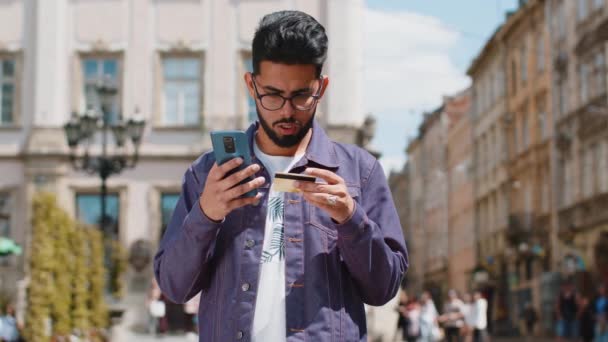 Radosny Młody Indianin Korzystający Smartfona Karty Kredytowej Podczas Przelewu Pieniędzy — Wideo stockowe