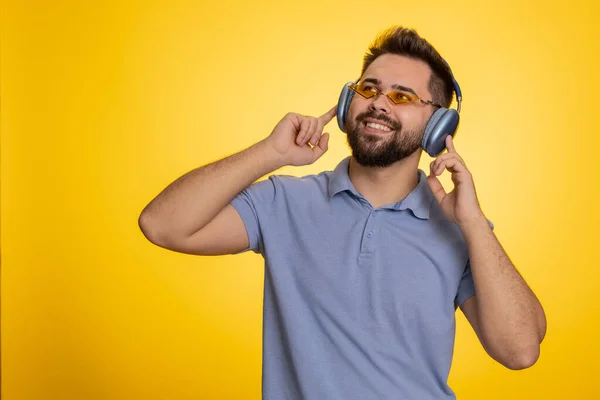 젊은이가 헤드폰을 춤추는 디스코를 음악을 노란색 스튜디오 배경에 고립된 실력있는 — 스톡 사진
