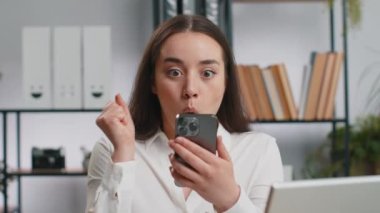 Aman Tanrım, vay canına. Akıllı telefon üzerinde çalışan Kafkasyalı mutlu iş kadını ani zafer, oyun kazanma, piyango hedefi başarısı ve iyi haberler karşısında şoka uğradı. Ofisteki güzel yönetici kız serbest çalışıyor.