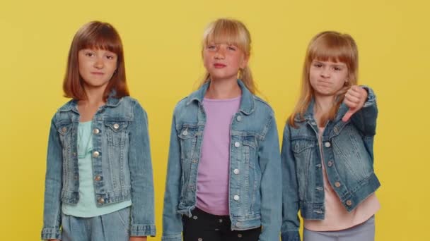 十代の少女は サインジェスチャーを示し 嫌悪を表しています 小さな子供たち スタジオ黄色の背景に隔離された3人の兄弟の子供 — ストック動画