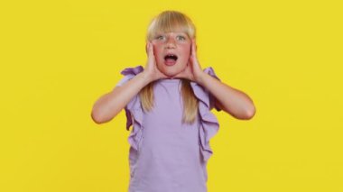 Aman Tanrım, vay canına. Genç kız çocuk büyük gözleriyle kameraya şaşırdı, piyango golü atan çocuklar için büyük bir şok oldu. Sarı arkaplanda izole edilmiş çocuklar