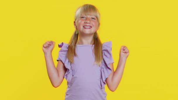 十几岁以下的小女孩大叫 举起拳头做手势我做了 庆祝成功 彩票中奖的目标实现男人 在黄色背景下被隔离的可爱小孩 — 图库视频影像