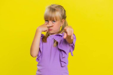 Gözüm üzerinde. Genç tatlı sarışın kız gözlerini ve kamerasını işaret ederek, jestini izlediğimi, birini gözetlediğini gösteriyor. Stüdyo sarısı arka planda izole edilmiş genç kız çocuk.