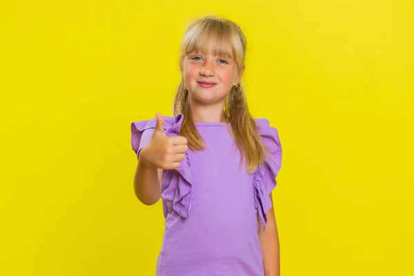 まるで 肯定的なフィードバック素晴らしいニュースのような肯定的な何かにサインアップ親指を示すカメラを見て幸せな若い未成年の子供の子供 スタジオ黄色の背景に隔離された子供たち — ストック写真