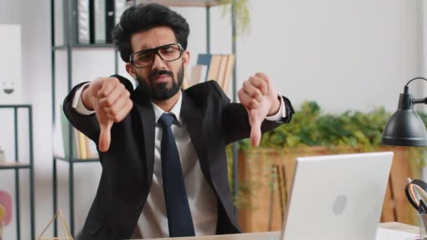 嫌いだ 自宅のオフィスの親指でラップトップコンピュータ上で働くインドのビジネスマンの男を動揺標識ジェスチャーを 不承認 不満を悪い仕事を表現する 不満な本気なフリーランスの男 — ストック動画