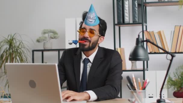 Aufgeregter Geschäftsmann Mit Sonnenbrille Festlicher Mütze Und Blasrohr Arbeitsplatz Beim — Stockvideo