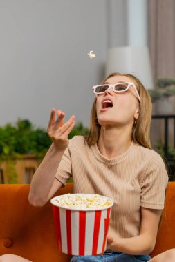 Heyecanlı kadın kanepeye oturur patlamış mısır yer, ağzıyla yakalamaya çalışır. Üç boyutlu gözlüklü bir kız evde ilginç televizyon dizileri, spor oyunları, filmler ve sosyal medya içerikli içerikler izliyor. Dikey