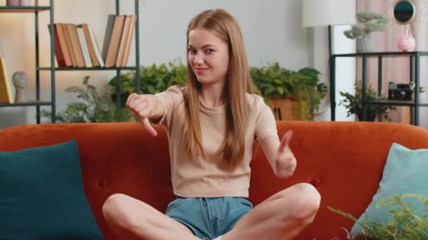 不喜欢 心烦意乱的女人的画像 低垂着大拇指的手势 表示不满 不满意 不满意在现代化的家庭公寓里的糟糕工作 沙发上客厅里不高兴的女孩 — 图库视频影像
