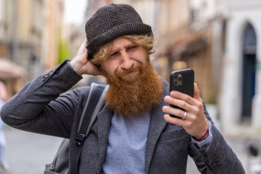 Şaşırmış sakallı adam akıllı telefon daktilo kullanıyor. Ani piyango sonuçlarını kaybediyor. Kötü haber, servet kaybı, başarısızlık. Şehir caddesinde yürüyen kızıl saçlı adam. Kasaba yaşam tarzları