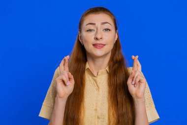 Şok olmuş bir kadın kameraya bakarak şans diliyor, iyi sınav sonuçları diliyor piyango ikramiyesinde zafer kazanmayı hayal ediyor. Mavi stüdyo arka planında izole edilmiş kız