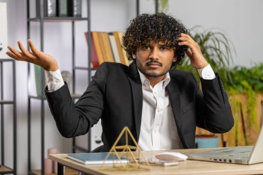 I dont know what to say. Confused business man working on laptop at office workplace. Freelancer feeling embarrassed about ambiguous question, having doubts, no answer idea, being clueless, uncertain