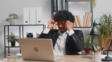 Güneş gözlüklü şanslı iş adamı iş yerinde dans eden zafer dansında şapkalı fötr şapka üflemeli pipo, hafta sonu. Proje geliştirme sevinci. Doğum gününü kutluyoruz. Piyango ikramiyesi. Ofisteki insanlar