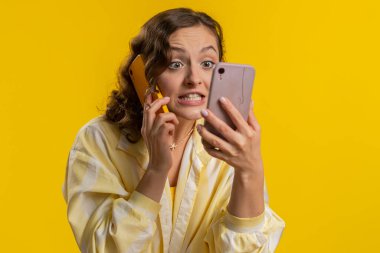 Sinirli, stresli genç bir kadın iki cep telefonuyla bağırarak konuşuyor. Tartışıyorlar. Şikayet anlaşmazlığı çözülüyor. Sarı stüdyo arka planında izole kız