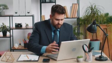 Laptop üzerinde çalışırken asabi Kafkasyalı iş adamı, beklenmedik internet sitesi sorunu, bilgisayar virüsü veri kaybı. Freelancer ofisteki kırık defter yüzünden kızgın.