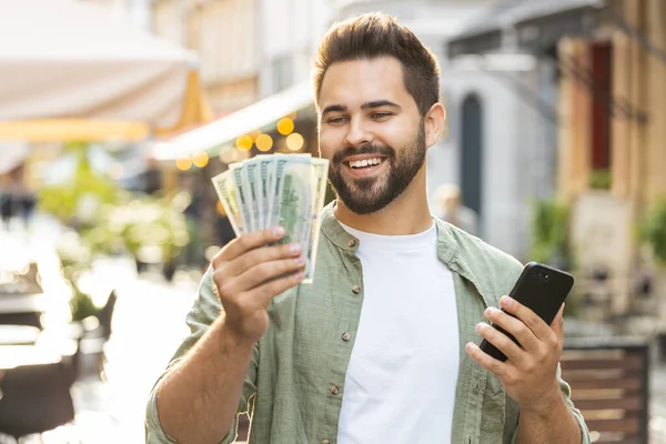 Happy Rich Young Man Counting Money Dollar Cash Use Smartphone — Stock Photo, Image