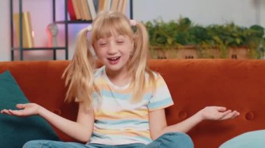 - Ne? - Neden? Küçük çocuk kız öfkeli bir ifadeyle el kaldırıyor, başarısızlık nedeni soruyor, sorunlardan kuşkulandığını gösteriyor. Oturma odasında kanepede oturan genç bir kız çocuk.