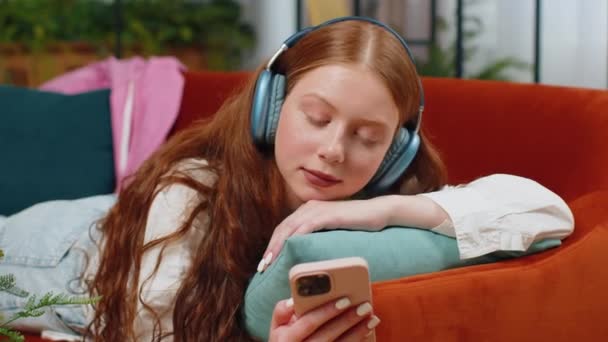 Teenager Šťastný Nadšený Dítě Dívka Bezdrátových Sluchátkách Relaxaci Ležící Gauči — Stock video