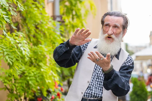 Neşeli, zengin, sakallı, yaşlı bir adam el hareketleriyle etrafa para saçıyor, daha fazla bahşiş veriyor, daha fazla kar ediyor, piyango kazanıyor, paylaşıyor, dışarıda kutluyor. Büyükbaba şehir sokağında duruyor.