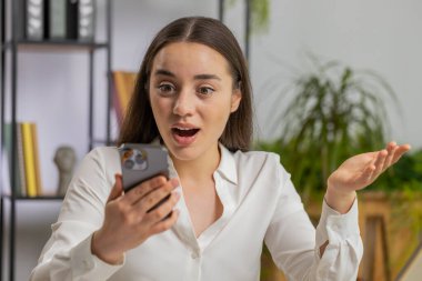 Aman Tanrım, vay canına. Akıllı telefon üzerinde çalışan Kafkasyalı mutlu iş kadını ani zafer, oyun kazanma, piyango hedefi başarısı ve iyi haberler karşısında şoka uğradı. Ofisteki güzel yönetici kız serbest çalışıyor.