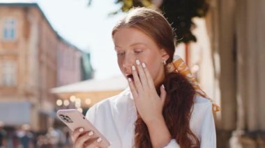 Genç kızıl saçlı kız akıllı telefon daktilo kullanıyor. Ani piyango sonuçlarını kaybediyor. Kötü haber, servet kaybı, başarısızlık. Şehir caddesinde yürüyen genç bir kadın. Kasaba yaşam tarzları