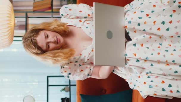 令人惊讶的是 使用笔记本电脑的红头发年轻女性在庆祝彩票中奖的同时 也在家里网上购物 垂直方向 — 图库视频影像