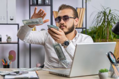 Neşeli, genç Lübnanlı iş adamı dizüstü bilgisayarla çalışıyor, daha fazla bahşiş için para harcıyor daha fazla bahşiş topluyor büyük kâr elde ediyor piyango alışverişi kazanıyor. Ev ofis masasındaki Bağımsız Arap Adam 'ın kutlu olsun.