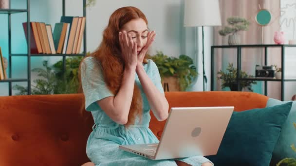 うわぁ ラップトップコンピュータを使用して驚きの赤毛の女性は 突然の勝利にショックを受けた良いニュースメッセージを受け取る自宅で宝くじジャックポットウィン購入を祝うオンラインショッピング ライフスタイル技術 — ストック動画