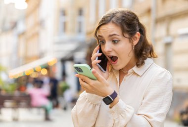 Sinirli, stresli genç bir kadın iki cep telefonuyla bağırarak konuşuyor. Tartışma halinde. Şikayet anlaşmazlığı dışarıda çözülüyor. Şehir caddesinde yürüyen kız