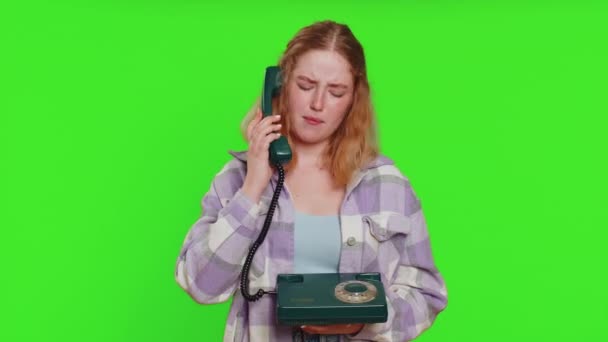 疲れた退屈な女性は80年代の有線ヴィンテージ電話で話し 馬鹿げた顔を作り 退屈な話に疲れ コミュニケーションの話に興味がない 緑色のクロマのキーバックに隔離された少女 — ストック動画