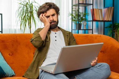 Memnun olmayan Ortadoğulu adam dizüstü bilgisayarı kullanıyor. Bilgisayarda arama yapıyor. Ani piyango kazasının kötü haber kaybı bilgisayar virüsü ile sonuçlanmasına şaşırıyor. Sınıftaki kanepede oturan genç adam