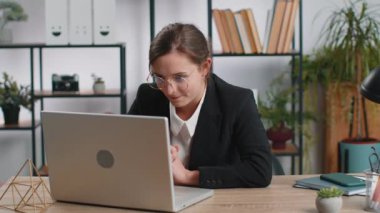 Beyaz bir iş kadını ofis masasında oturuyor ve işini bitirdikten sonra bilgisayarı kapatıyor. Çevrimiçi uzaktan kumanda işinde çalışan serbest çalışan bir kız. Defter bilgisayarında e-öğrenme, internette gezinme