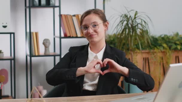 愛してるわ 白人のビジネス女性は 愛の象徴を作り カメラに心のサインを示し ロマンチックな感情を表現し オフィスの職場で誠実な肯定的な感情を表現します — ストック動画