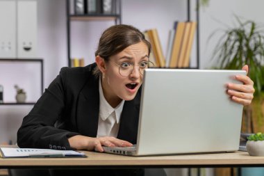 Laptop üzerinde çalışırken asabi Kafkasyalı iş kadını, beklenmedik internet sitesi sorunu, bilgisayar virüsü veri kaybı. Freelancer ofisteki iş yerinde kızgın, kırık bir defter gibi hissediyor.