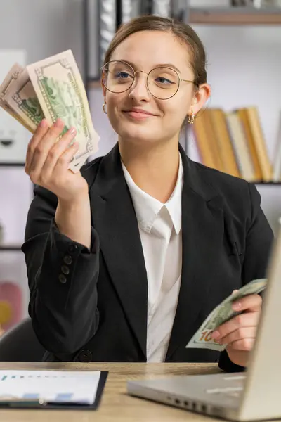 お金の現金を数えるラップトップで働く豊かなビジネス女性は 家庭のオフィスの職場で収入の利益を計算します プロのマネージャー フリーランサーの女の子がスーツを着ています 雇用占領について バーティカル — ストック写真