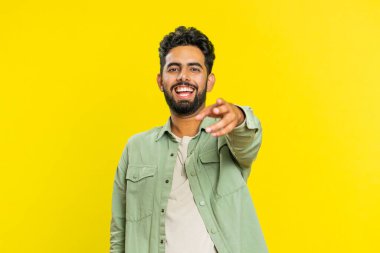 Gülünç anekdotları duyduktan sonra gülen mutlu Hintli genç adam komik şakalara tepki veriyor, kaygısız bir şekilde eğleniyor. Pozitif insanların yaşam tarzı. Stüdyo sarı arka planda izole edilmiş Arap bir adam.