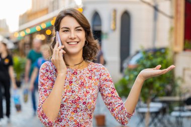 Telefon, iyi haber, dedikodu. Akıllı telefonda hoş sohbetler yapan mutlu, beyaz bir bayan, dışarıda arkadaşlarıyla konuşmaktan zevk alıyor. Şehir caddesinde duran yetişkin bir kız. Uzayı kopyala