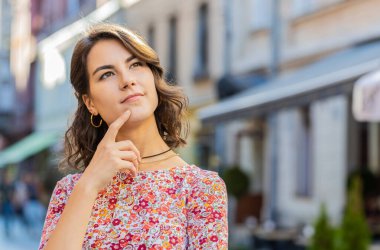 Düşünceli, dalgın, kafası karışık, düşünceli genç bir kadın. Düşünceli bir ifadeyle çözümü düşünüyor, şüpheci bir soru soruyor, açık havada hayaller kuruyor. Şehir sokağında yetişkin bir kız. Kasaba yaşam tarzları